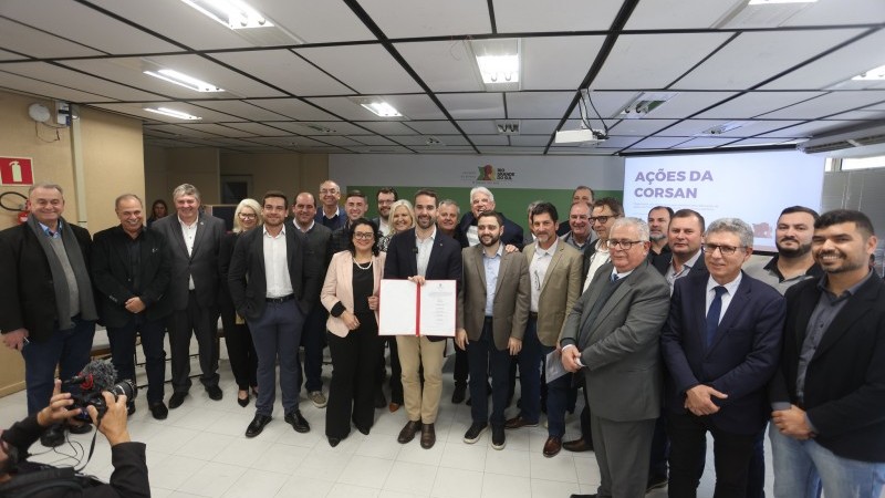 Prefeitos reunidos em forma de ferradura. Ao centro o governador Eduardo Leite com o documento do ato do pagamento das ações em mãos. À direita do governador a secretária da Sema, Marjorie Kauffmann, à esquerda o vice-governador, Gabriel Souza.