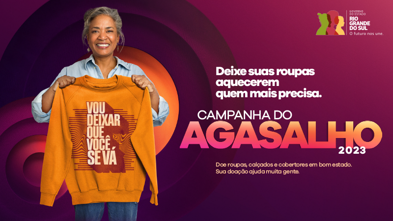 marca da campanha do agasalho deste ano. Uma senhora negra segurando um moleton na cor laranja com a frase temática da campanha. "vou deixar que você se vá".