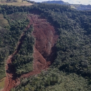Imagem aérea de uma área de floresta com um grande deslizamento de terra.