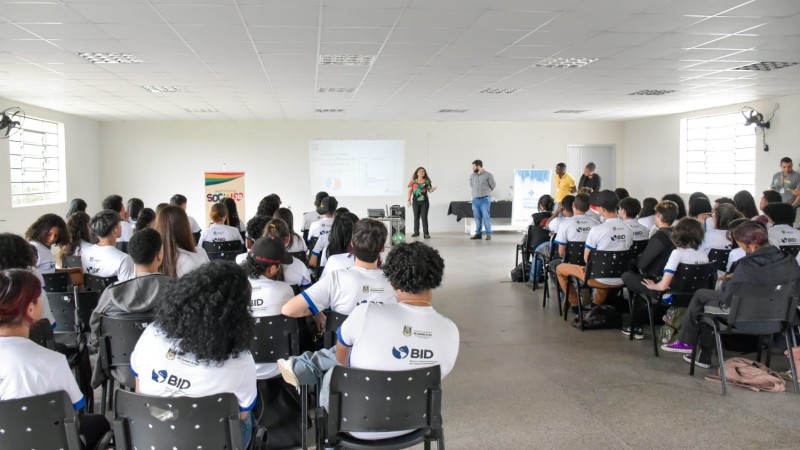 Auditório com estudantes prestando atenção durante a fala da bióloga da Sema.