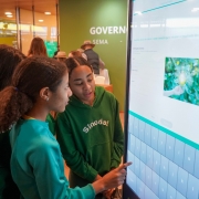 Estudantes utilizam totem interativo na Expointer. Uma das alunas est&aacute; clicando a tela.